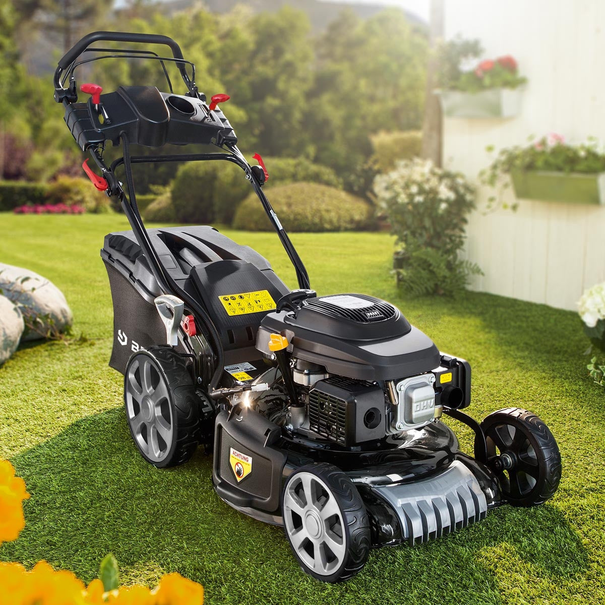 Schwarzer Benzin-Rasenmäher mit 20-Zoll-Mähdeck, großem Fangkorb und E-Start-Griff an sonnigem Gartenstandort.