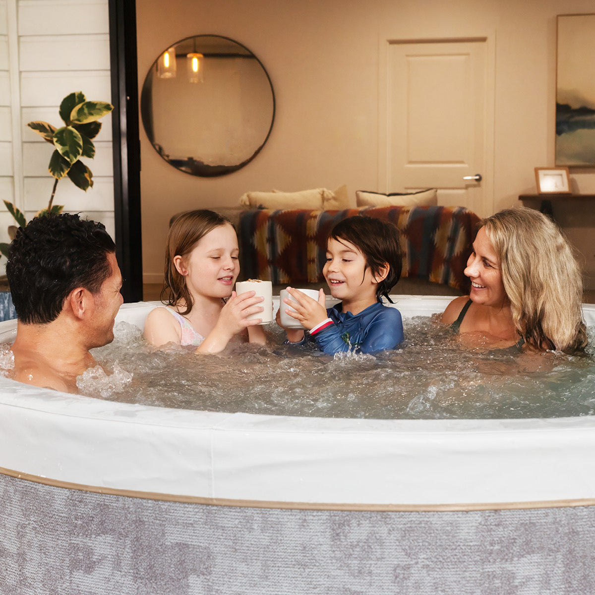 Runder halbfester Whirlpool mit grauer Außenhülle, sechs Personen genießen Wasser und Getränke.