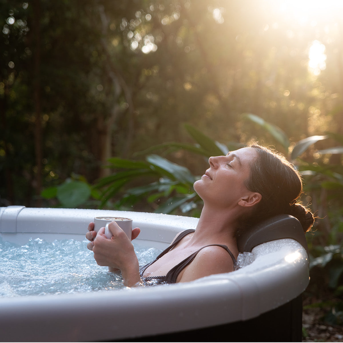 Halbfester runder Whirlpool mit LED-Beleuchtung und Wasserstrahlen, Frau entspannt im Freien.