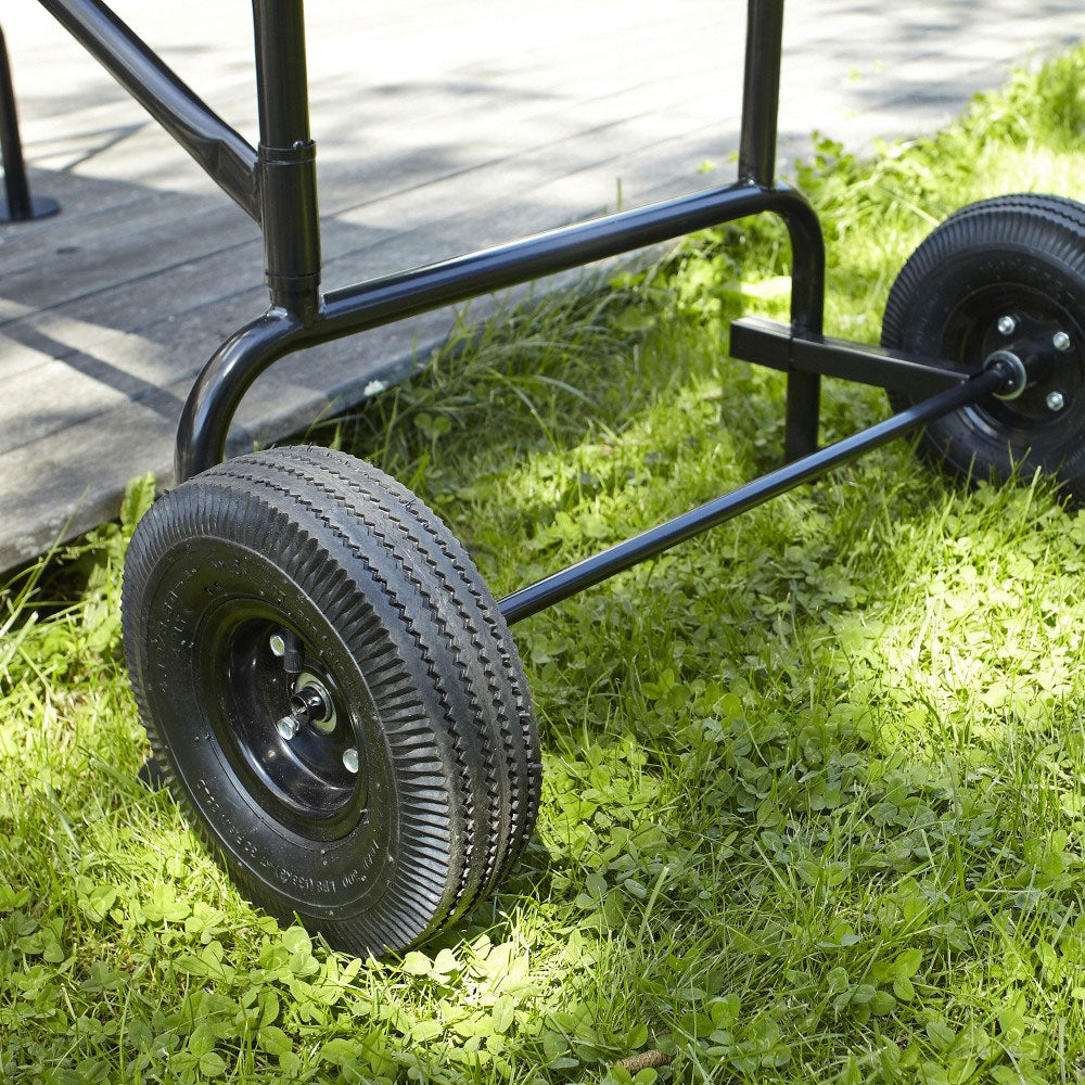 Mobiles Arbeitsgerüst mit großen luftgefüllten Reifen auf Grasfläche.