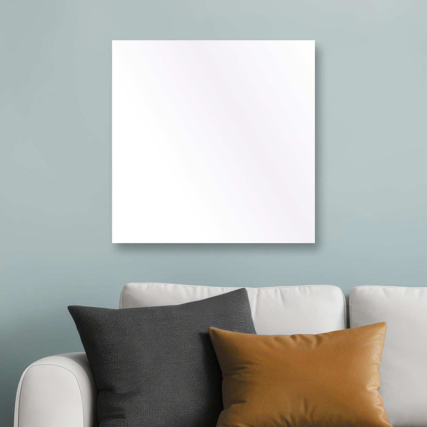 Quadratische weiße Wand-Infrarotheizung über grauem Sofa mit schwarzem und braunem Kissen.