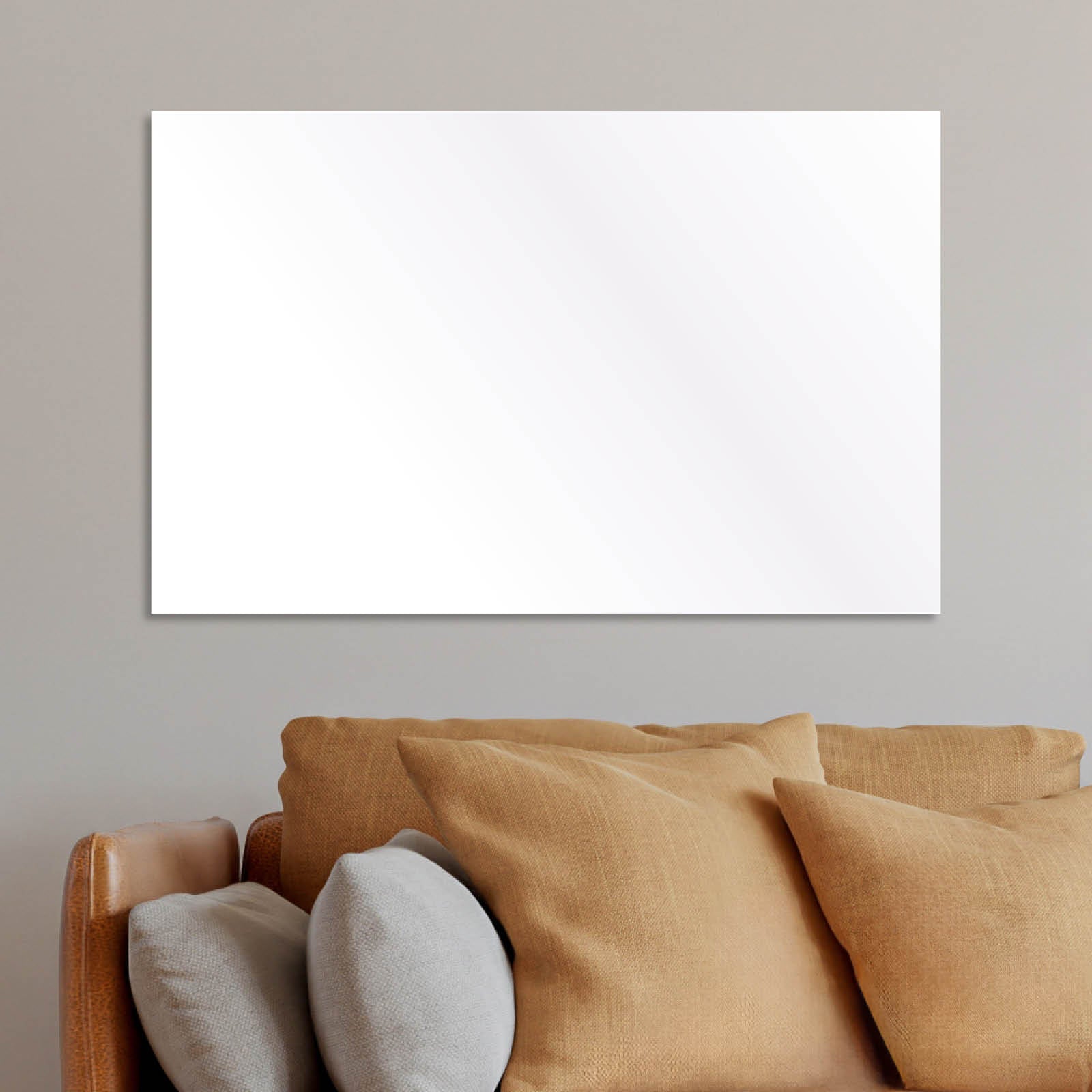 Weiße rechteckige Infrarotheizung mit glatter Oberfläche an grauer Wand über braunem Sofa.
