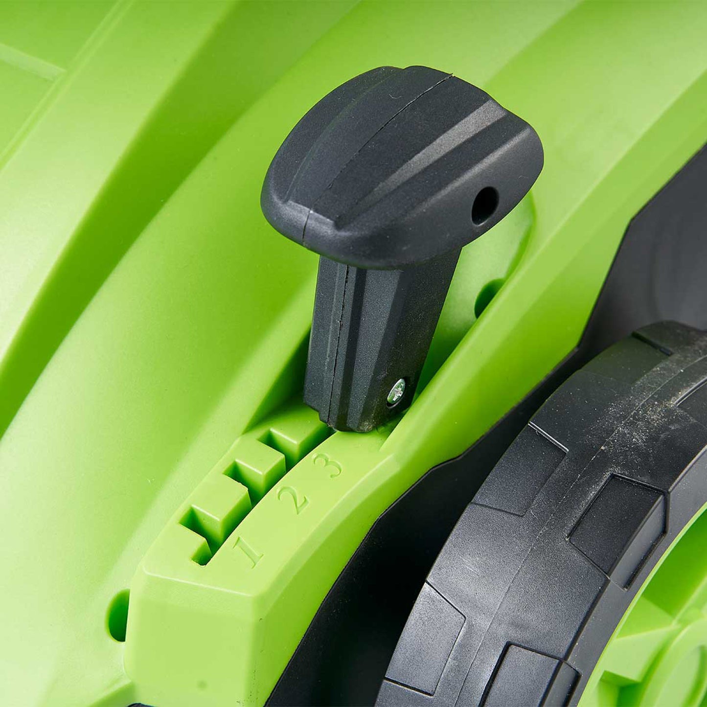 Grüner Hebel zur Höheneinstellung am Rasenvertikutierer mit robustem Radantrieb.