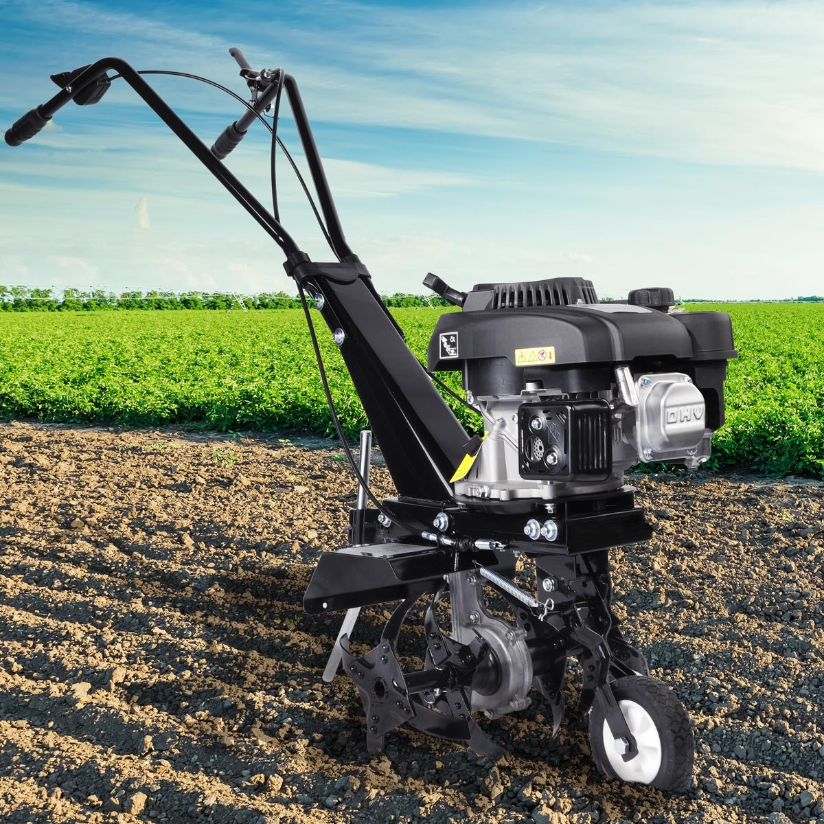 Schwarze Benzin Motorhacke mit griffbarer Gartenfräse, Bodenfräse und Gartenfräse Pflug auf Ackerboden.