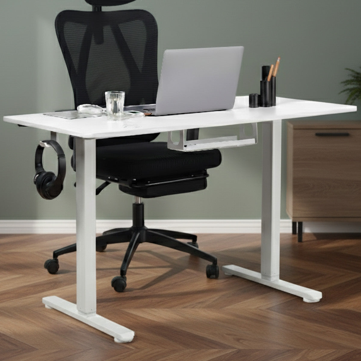 Weißer höhenverstellbarer Schreibtisch mit minimalistischer Oberfläche und Metallgestell, darunter Halterung für Headset.
