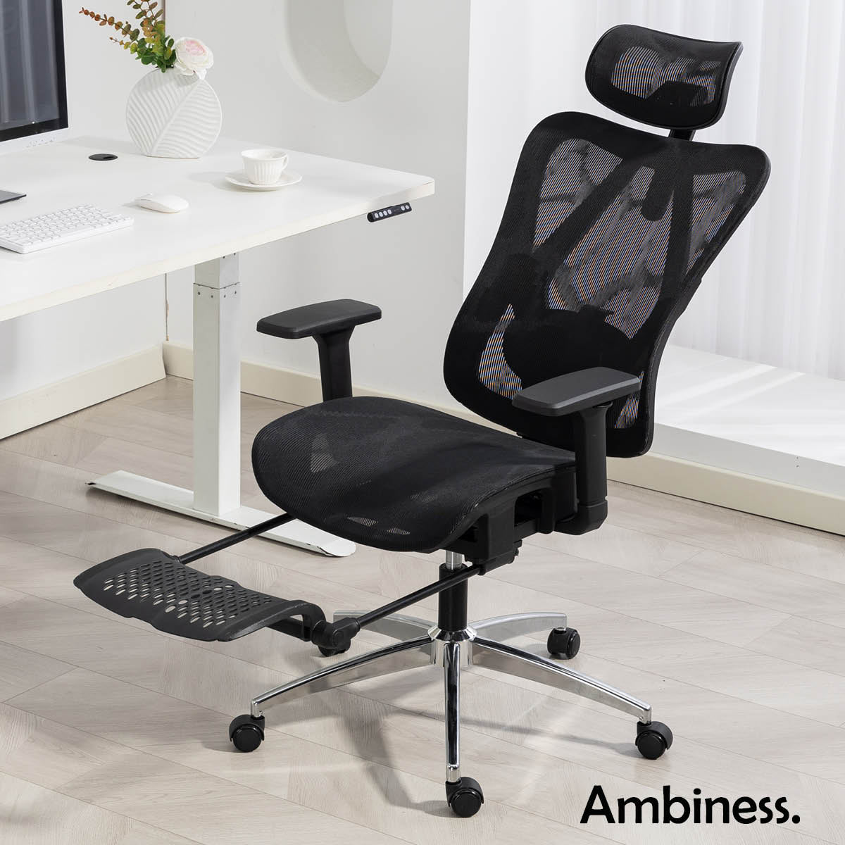 Schwarzer Bürostuhl mit Netzbespannung, verstellbarer Kopfstütze und ausziehbarer Fußstütze, chromfarbener Metallrahmen.