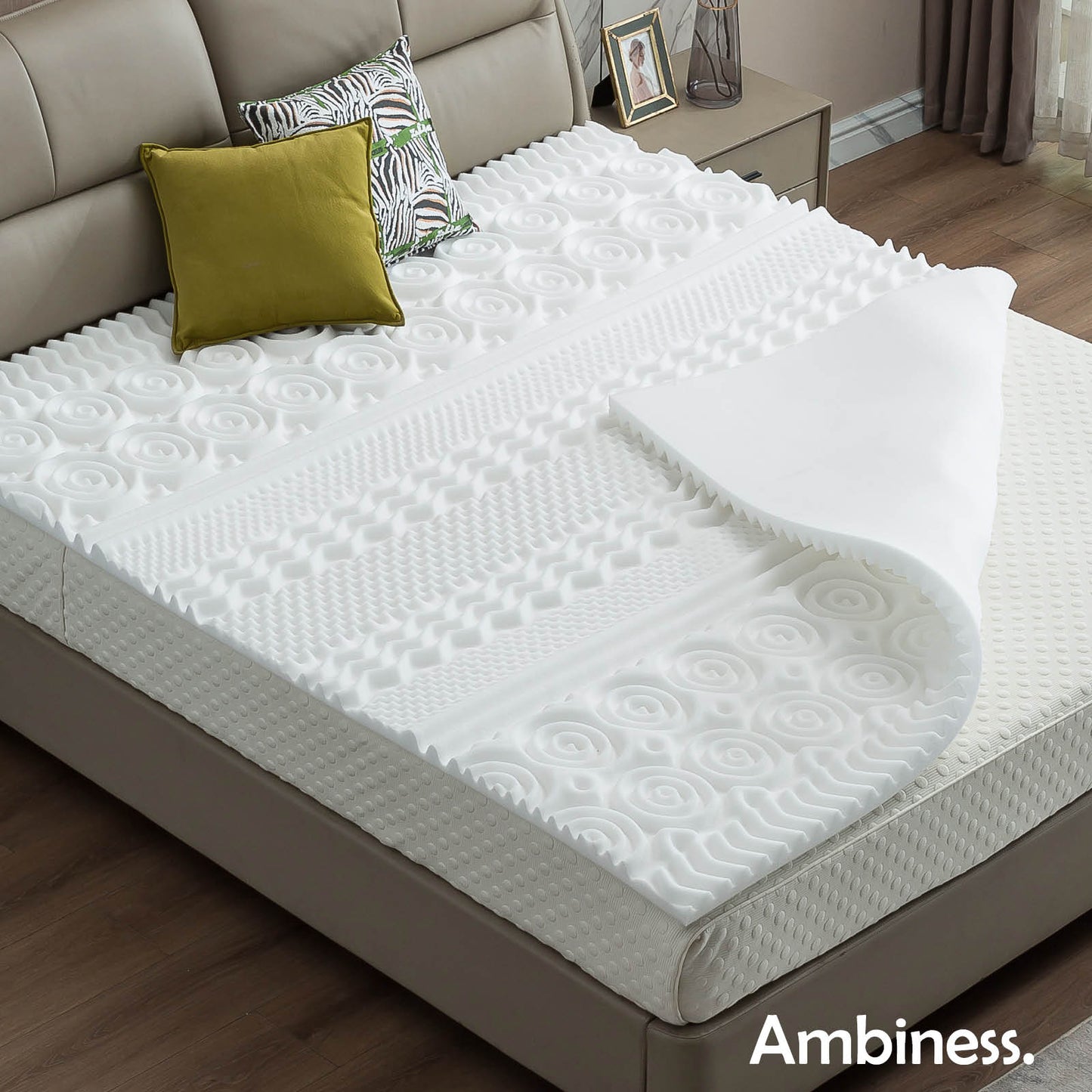 Weißer Matratzen Topper aus Memory Schaum mit 13 Zonen, auf grauem Bettgestell liegend.