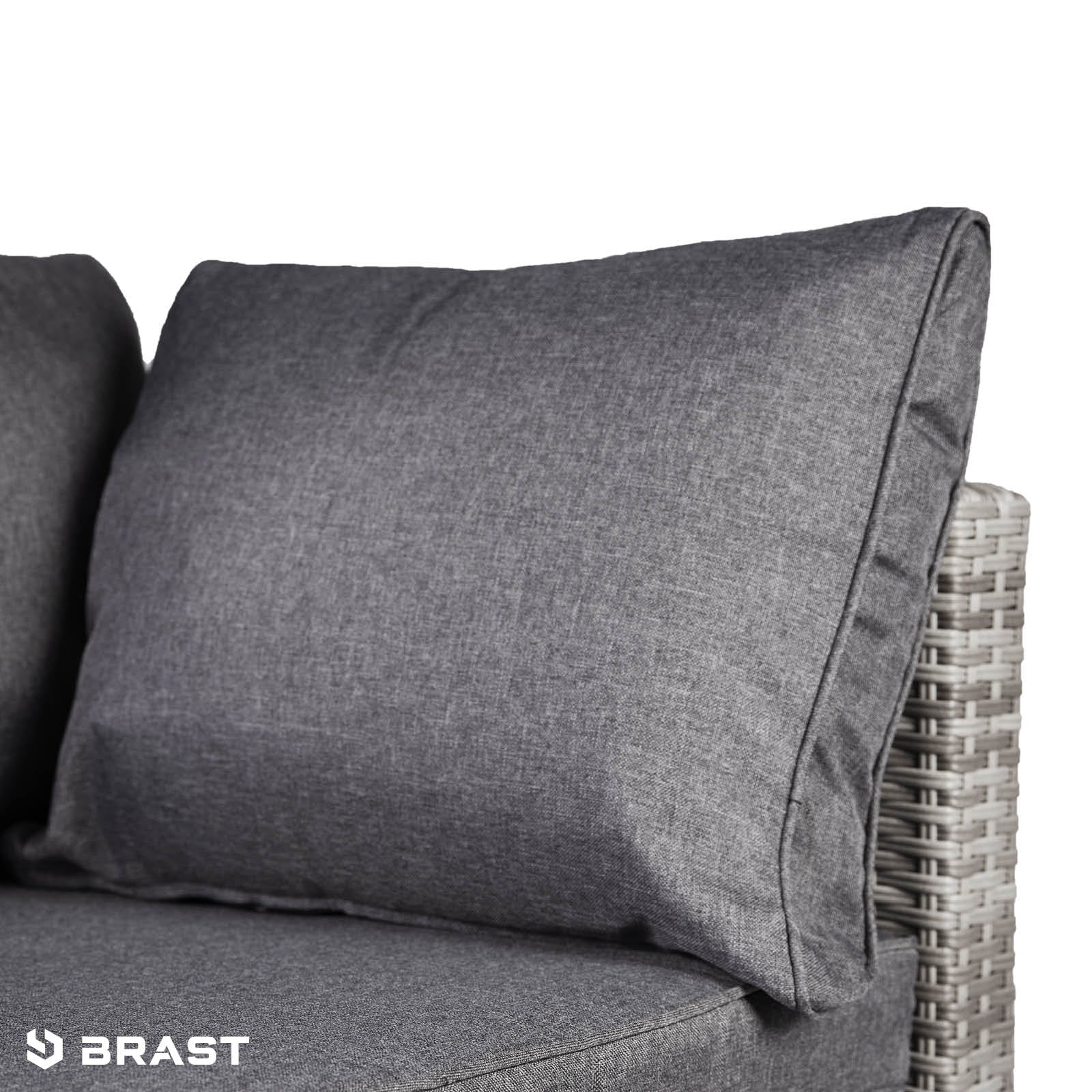 Grau gepolstertes Kissen auf hellem Rattan Lounge Gartenmöbel Loungemöbel Set.