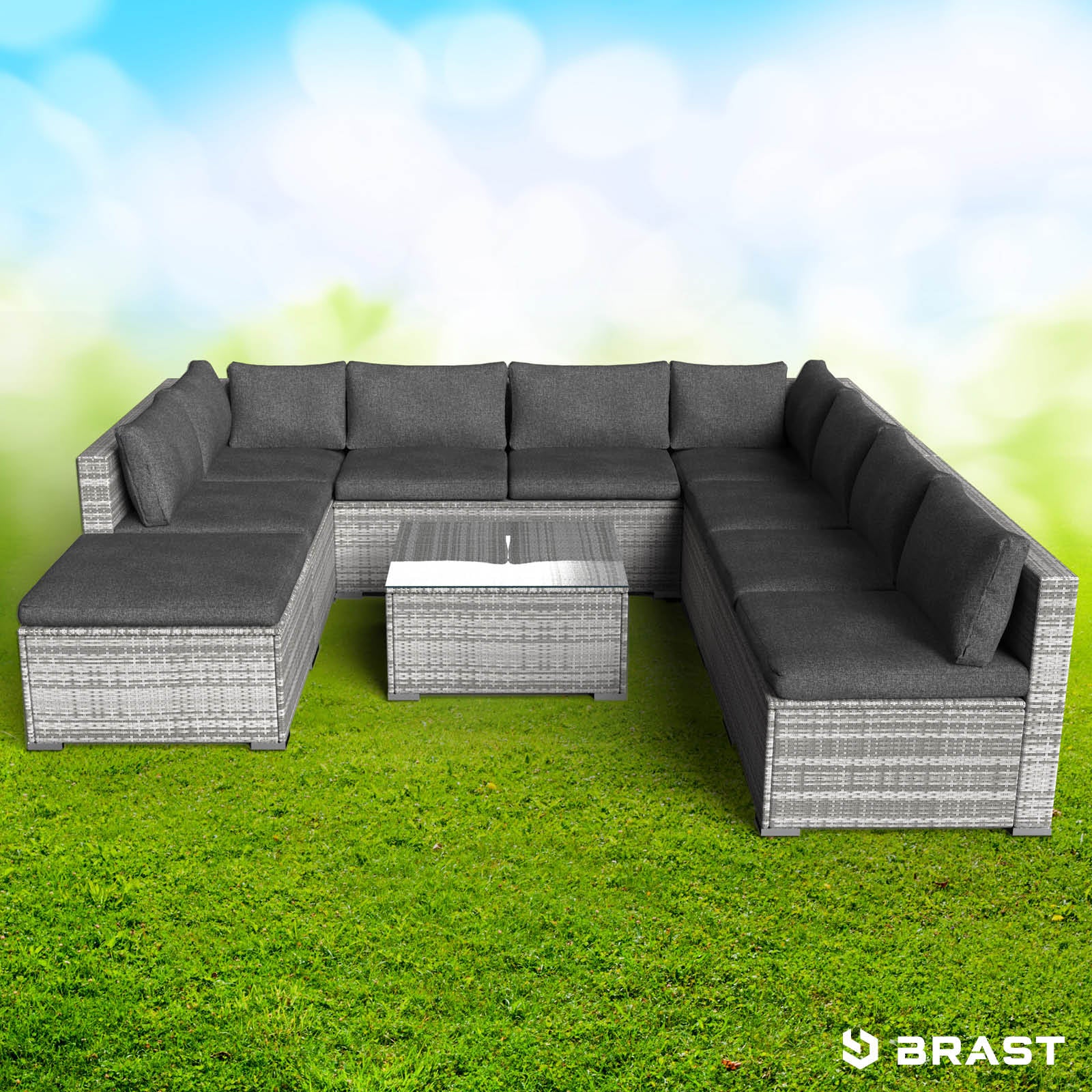 Großes graues Rattan Lounge Gartenmöbel Set mit Polsterkissen und Tisch auf grünem Rasen.