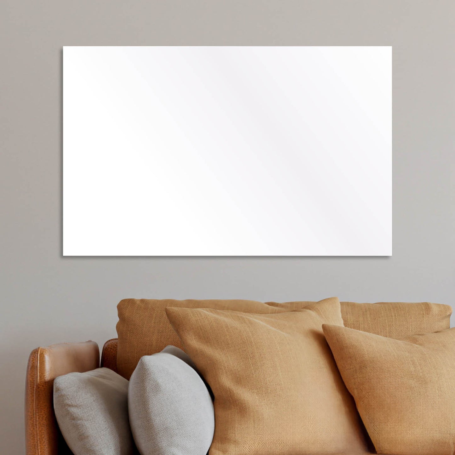 Weiße, flache Infrarotheizung mit glatter Oberfläche an grauer Wand über braunem Sofa mit Kissen.