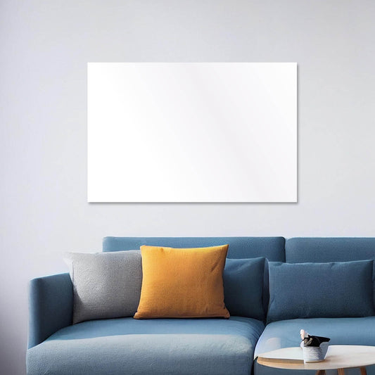 Weiße rechteckige Hybrid Infrarotheizung über blauem Sofa mit grauem und orangefarbenem Kissen.